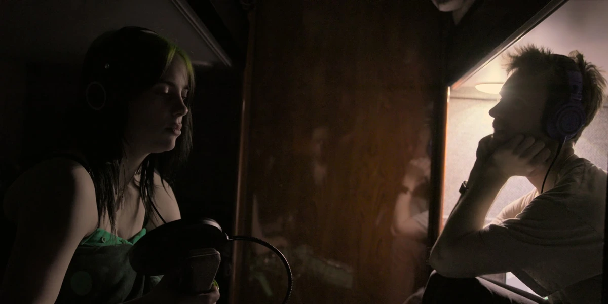 Billie Eilish and Finneas during an intimate recording session in a dim studio