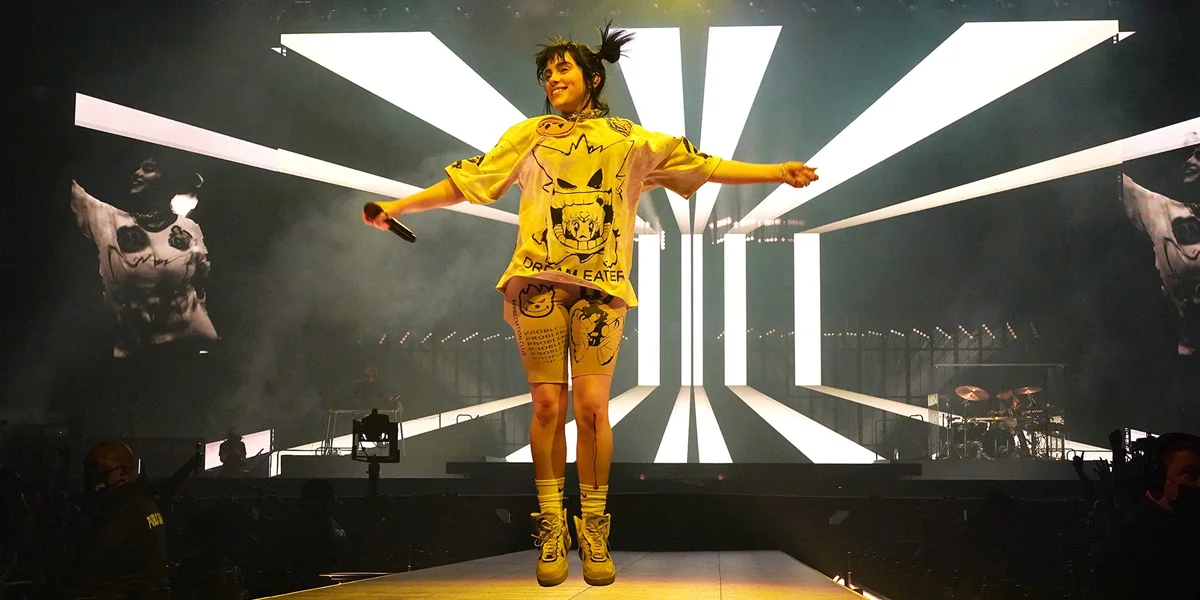 Billie Eilish performing energetically on stage during the Happier Than Ever era