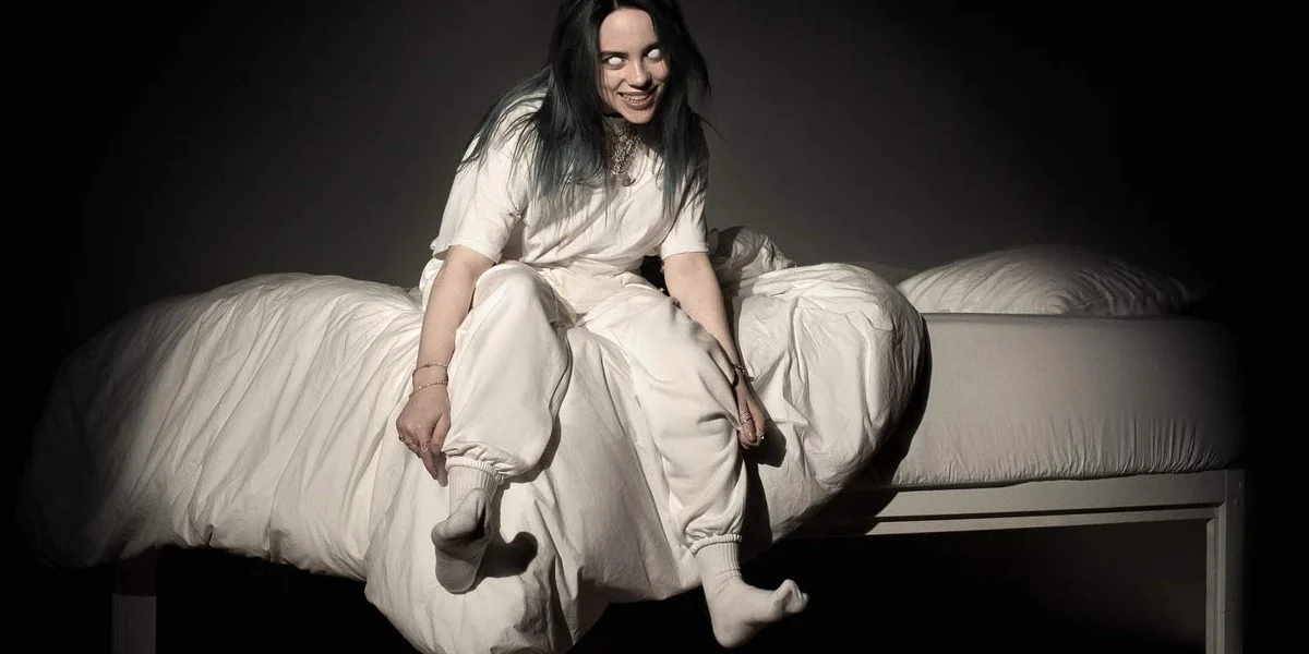 Billie Eilish sitting on a bed surrounded by darkness in a surreal cinematic setting