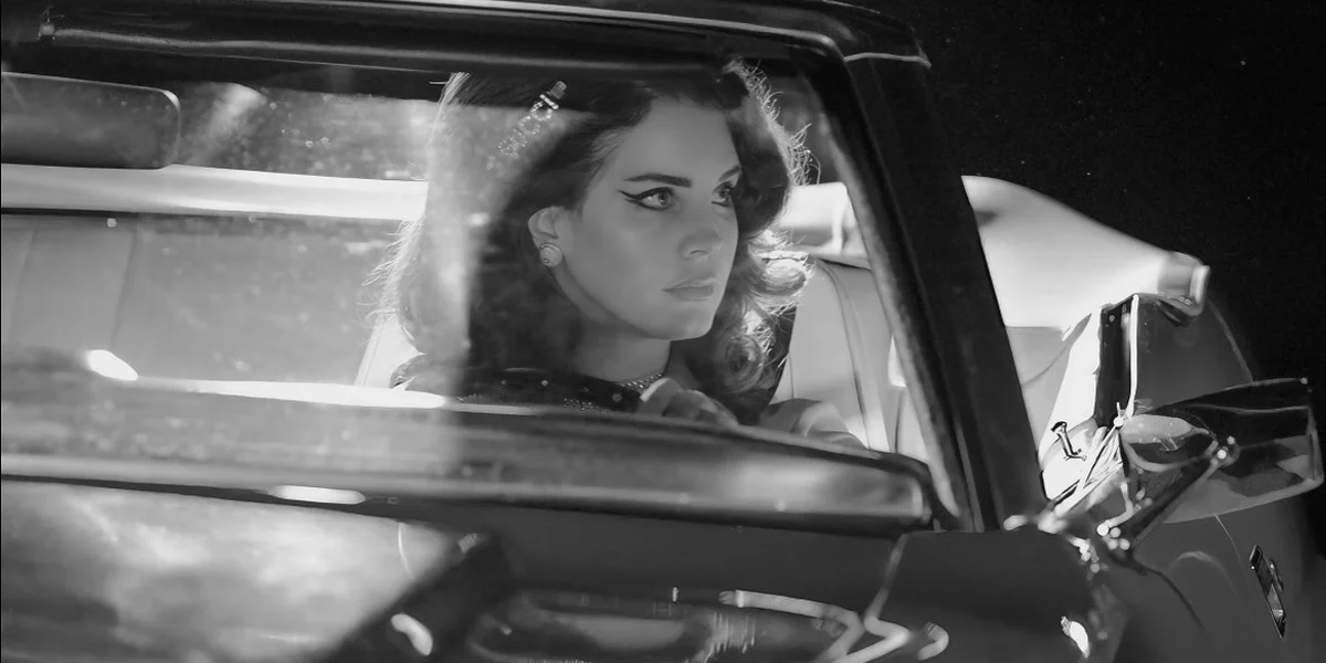 Lana Del Rey sitting alone in a car in a black and white Gucci campaign photographed by Glen Luchford