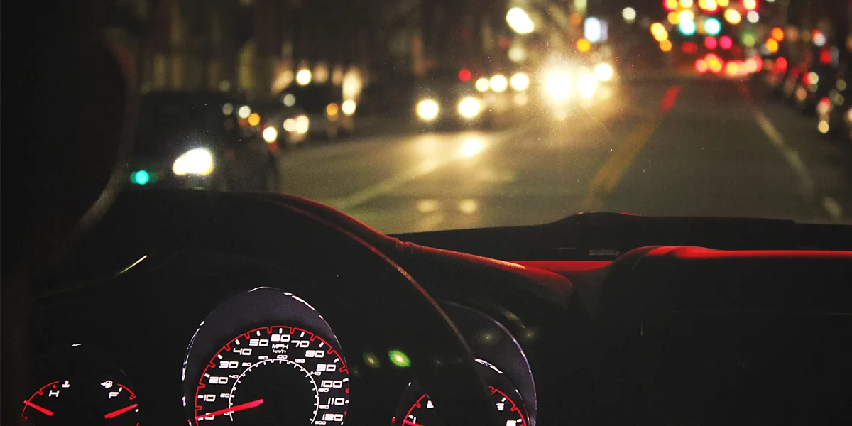Late night driving view through a car windshield with blurred city lights