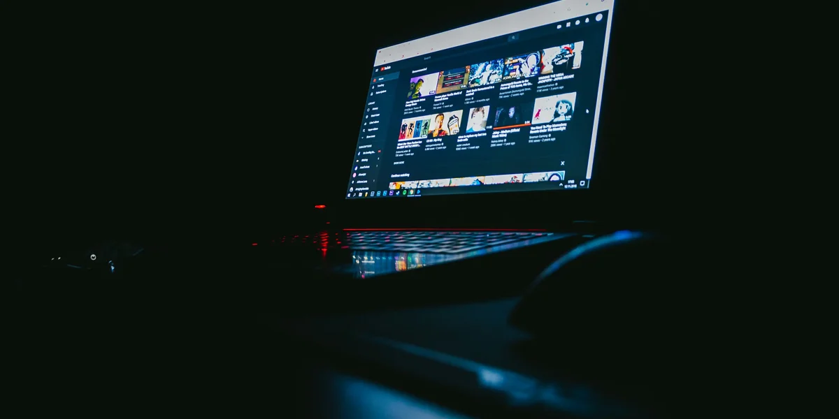 Laptop screen glowing in a dark room during a late night moment of internet isolation