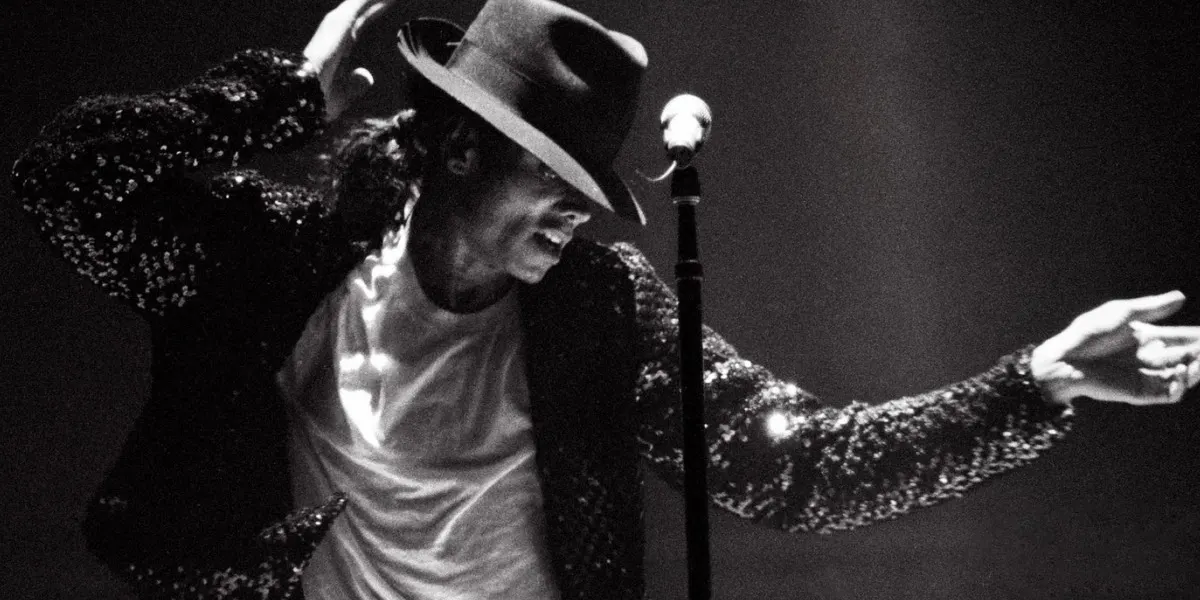 Michael Jackson performing on stage in his iconic fedora and sequined jacket during the Billie Jean era